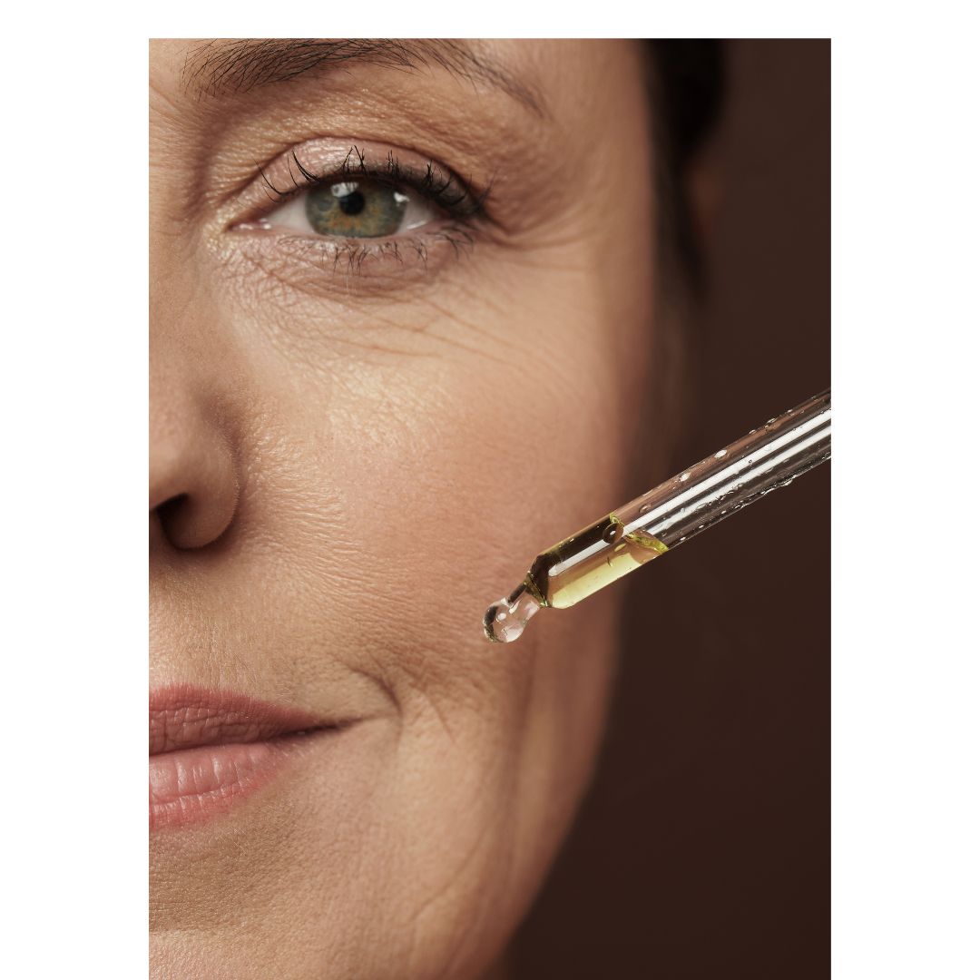 Woman applying Ané Glow in a Bottle face oil